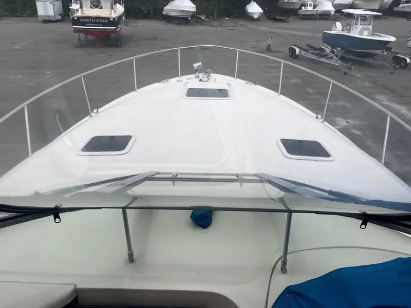 Slide: The Image of 2000 Sea Ray 340 Sundancer boat on land, view from cockpit, surrounded by other boats. - 23