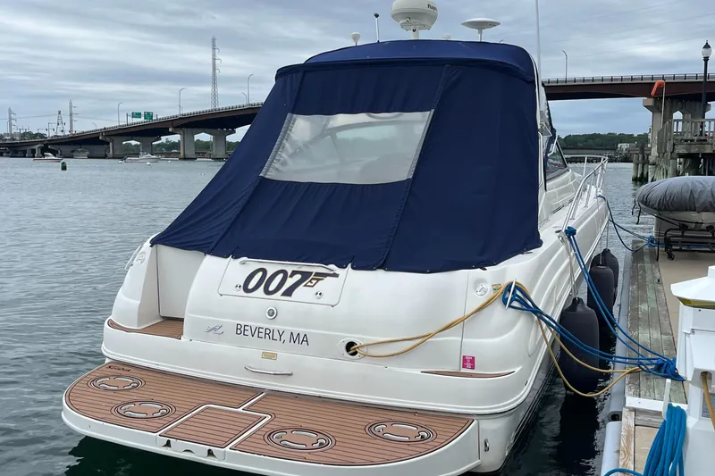 Slide: The Image of 2000 Sea Ray 340 Sundancer docked, featuring blue cover and "007" marking, Beverly, MA. - 27