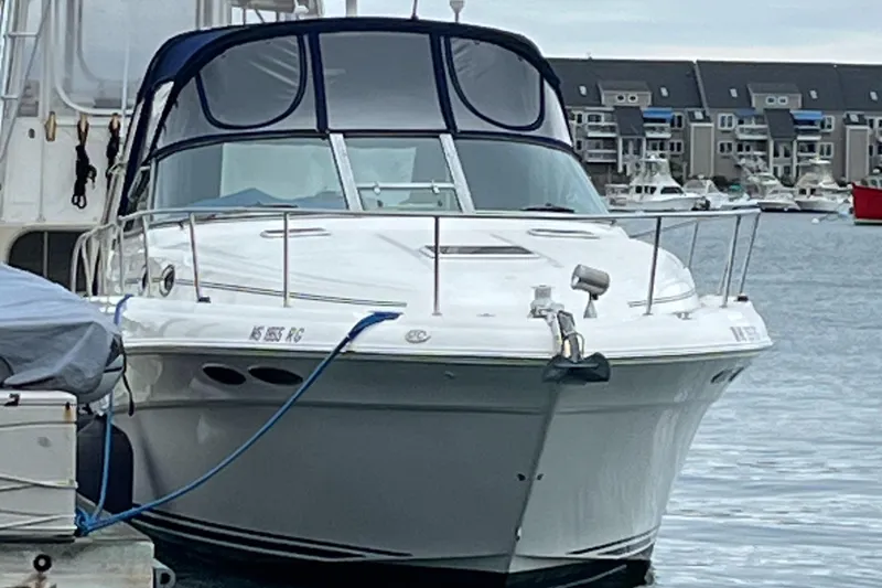 Slide: The Image of 2000 Sea Ray 340 Sundancer docked in a marina, featuring sleek design and blue canopy. - 29