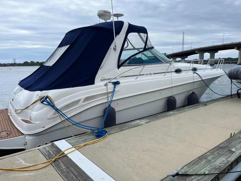 Slide: The Image of 2000 Sea Ray 340 Sundancer yacht docked by the waterfront with blue canopy. - 3