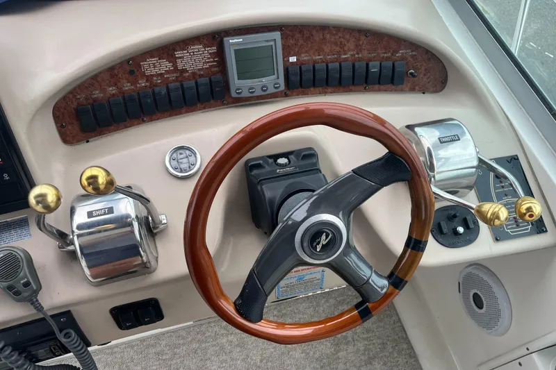 Slide: The Image of Control panel of a 2000 Sea Ray 340 Sundancer boat with wooden steering wheel. - 38