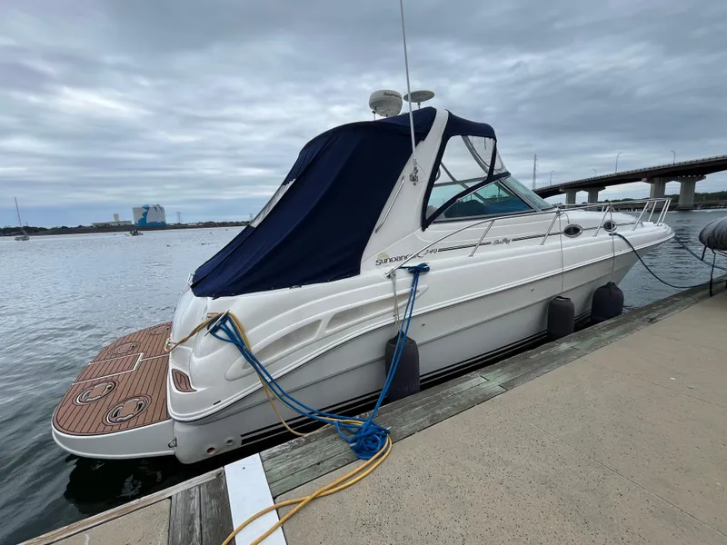 Slide: The Image of 2000 Sea Ray 340 Sundancer docked by a waterfront under cloudy skies. - 4