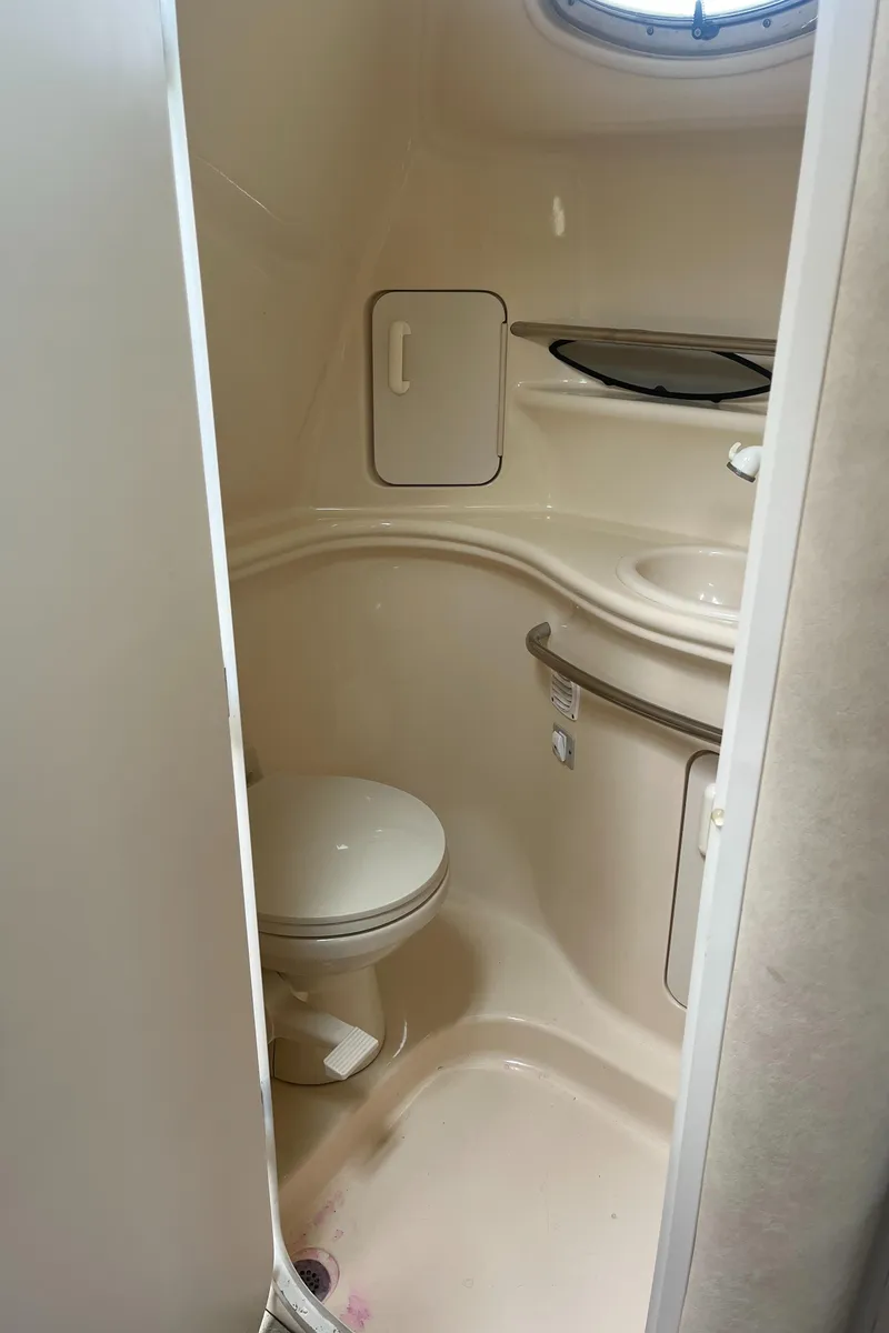 Slide: The Image of 2000 Sea Ray 340 Sundancer bathroom with toilet, sink, and storage cabinet. - 44