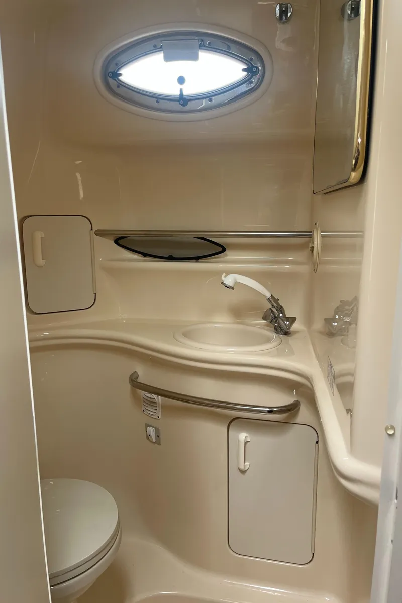 Slide: The Image of 2000 Sea Ray 340 Sundancer bathroom with sink, toilet, and porthole window. - 45