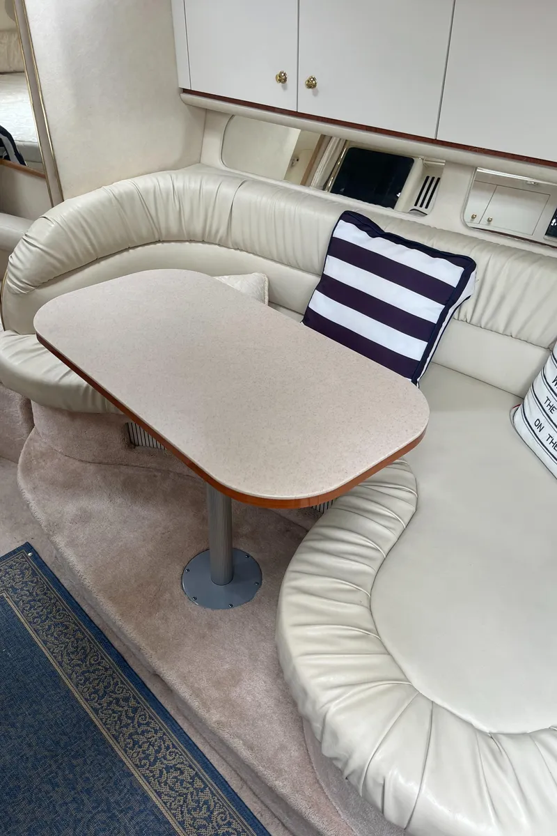 Slide: The Image of Interior of 2000 Sea Ray 340 Sundancer with cream leather seating and striped cushions. - 46