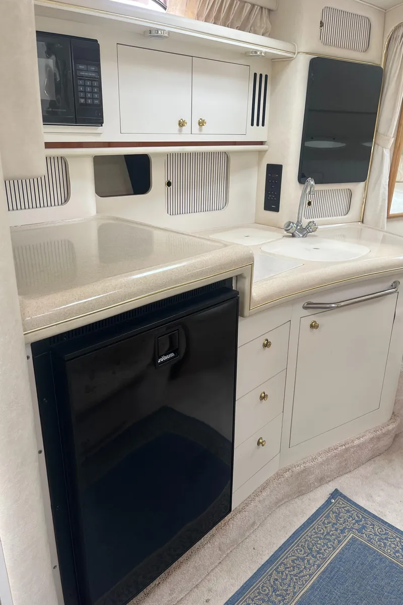 Slide: The Image of 2000 Sea Ray 340 Sundancer kitchen with fridge, sink, and microwave. - 47
