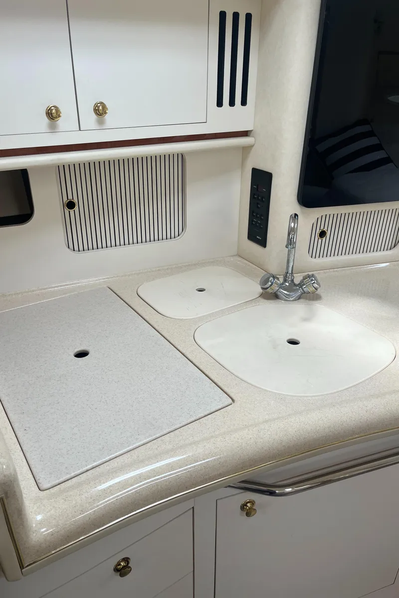 Slide: The Image of 2000 Sea Ray 340 Sundancer kitchen with sink, faucet, and storage cabinets. - 49