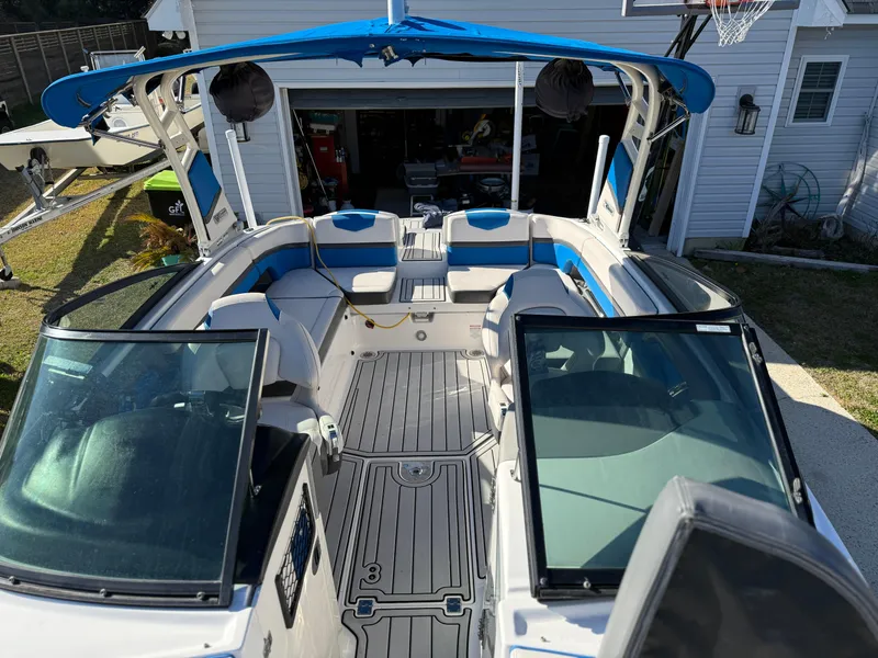 Slide: The Image of 2017 Chaparral Vortex 2430 VRX boat with blue canopy in a driveway. - 14