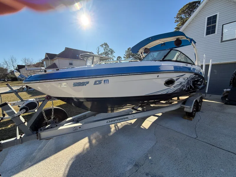 Slide: The Image of 2017 Chaparral Vortex 2430 VRX boat on trailer, parked in driveway under sunny sky. - 3