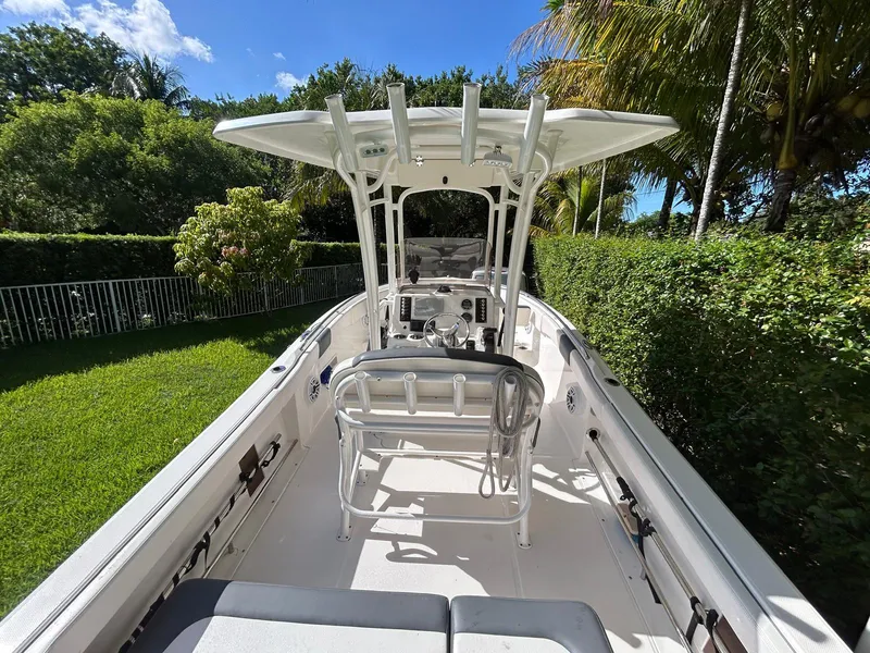 Slide: The Image of 2018 Robalo R222 boat with T-top, surrounded by lush greenery. - 5