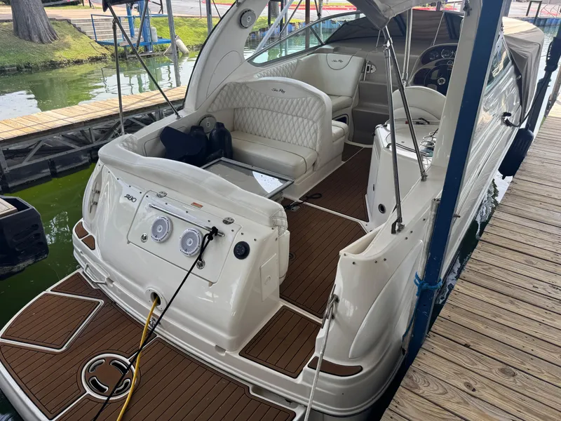 Slide: The Image of 2003 Sea Ray 280 Sundancer boat docked, featuring spacious seating and elegant design. - 4
