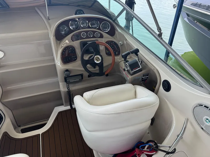 Slide: The Image of 2003 Sea Ray 280 Sundancer helm with gauges, steering wheel, and controls. - 7