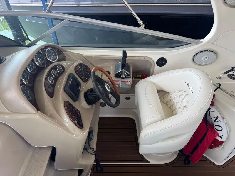 Slide: The Image of 2003 Sea Ray 280 Sundancer helm with gauges, steering wheel, and white captain's chair. - 8