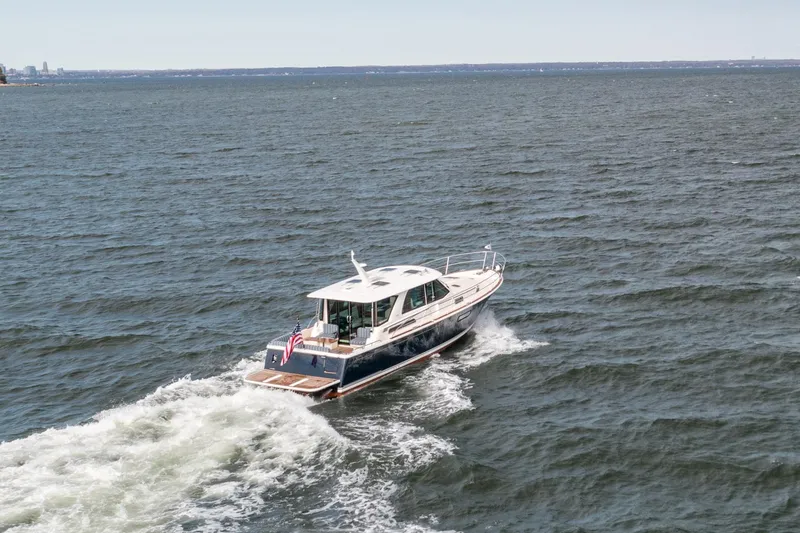 Slide: The Image of 2025 Sabre 43 Salon Express cruising on open water, rear view. - 11