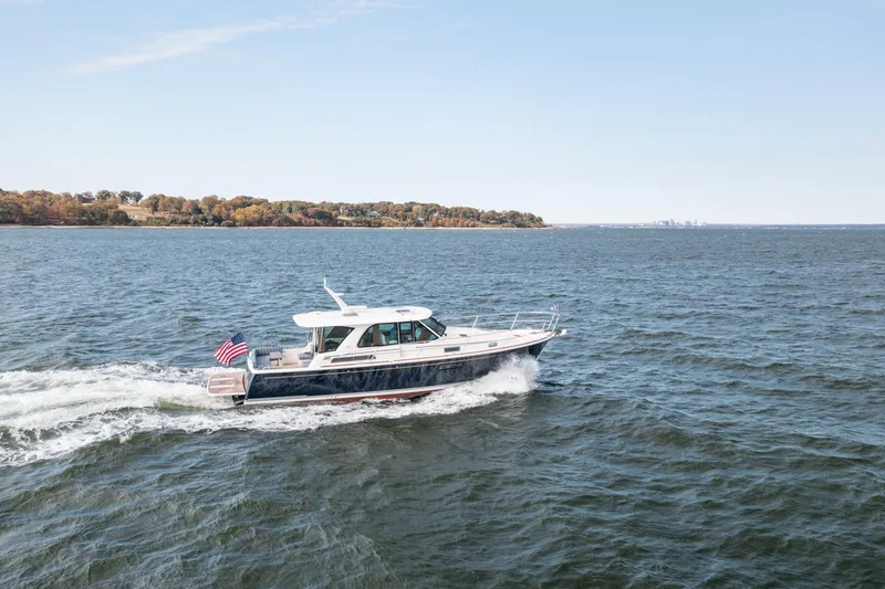 Slide: The Image of 2025 Sabre 43 Salon Express yacht cruising on open water, American flag displayed. - 12