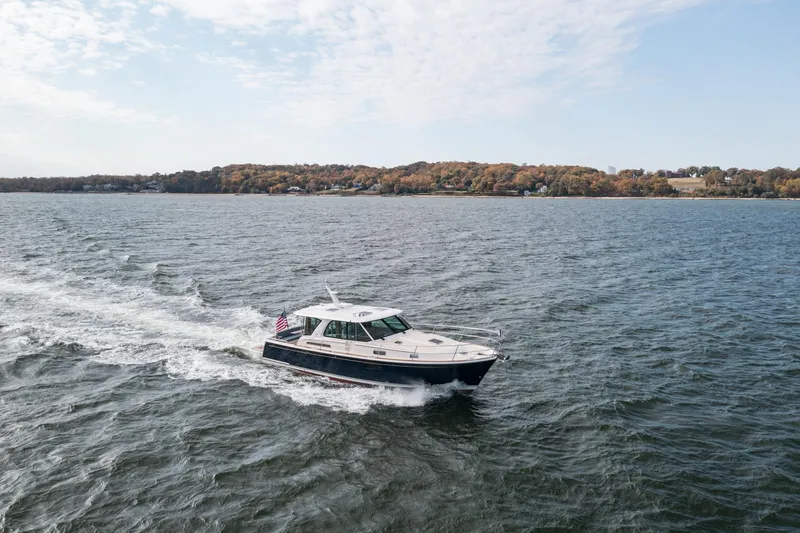 Slide: The Image of 2025 Sabre 43 Salon Express cruising on a scenic lake with autumn foliage. - 14