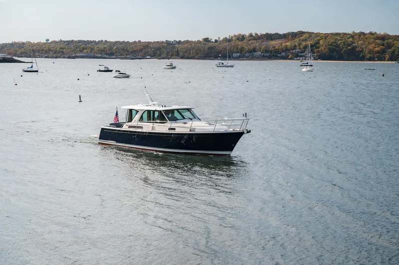 Slide: The Image of 2025 Sabre 43 Salon Express cruising on a scenic lake with sailboats in the background. - 16