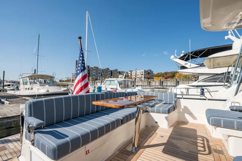 Slide: The Image of 2025 Sabre 43 Salon Express yacht with striped seating and American flag at marina. - 20
