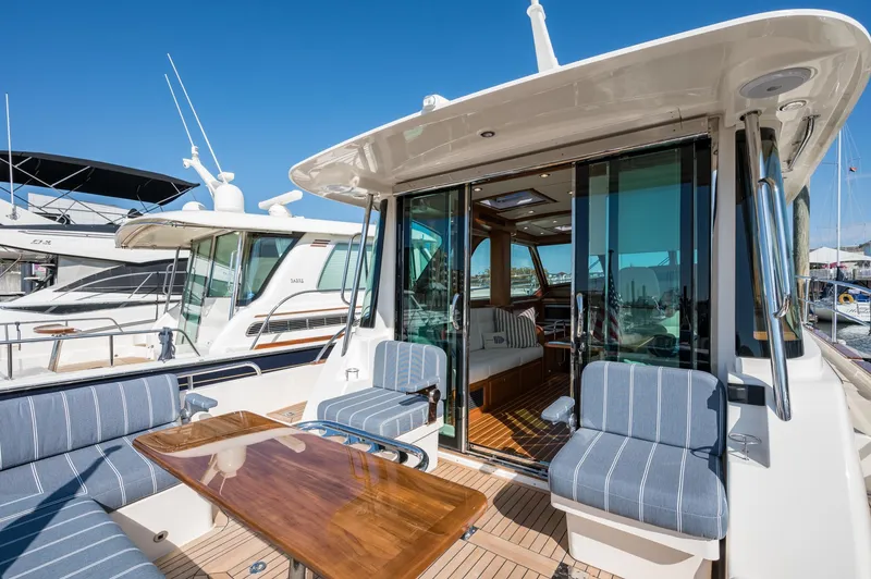 Slide: The Image of 2025 Sabre 43 Salon Express yacht with elegant seating and wooden table on deck. - 21