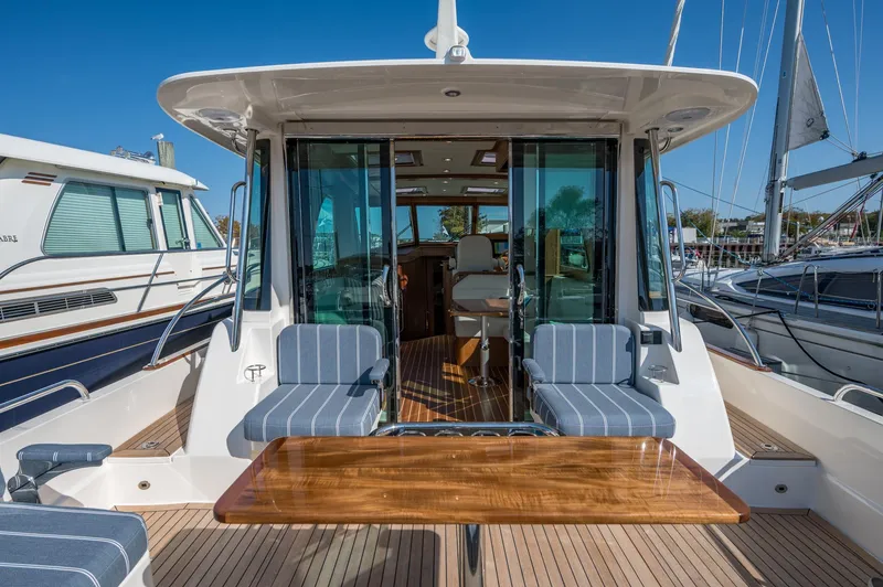 Slide: The Image of 2025 Sabre 43 Salon Express yacht with elegant seating and wooden table on deck. - 22