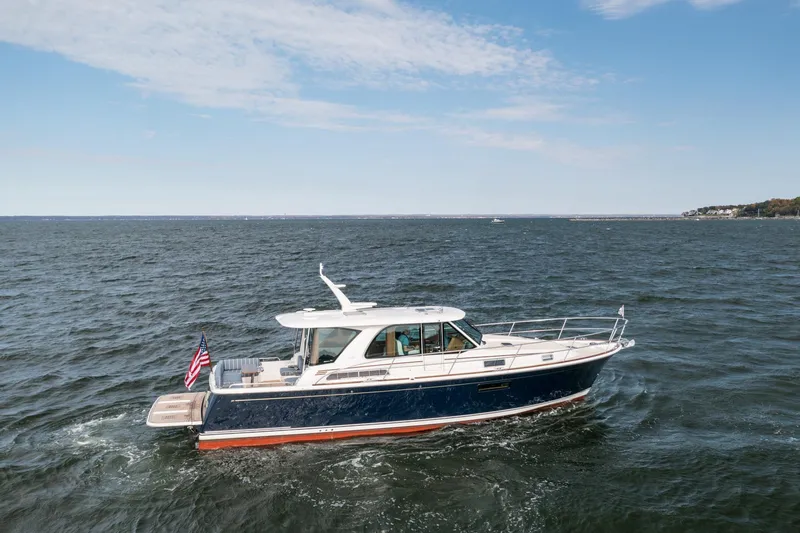 Slide: The Image of 2025 Sabre 43 Salon Express yacht cruising on open water under a clear sky. - 3