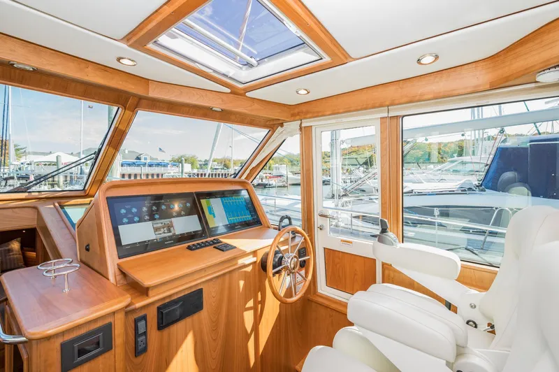 Slide: The Image of 2025 Sabre 43 Salon Express yacht interior with modern helm and panoramic windows. - 30