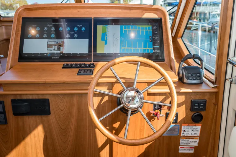 Slide: The Image of 2025 Sabre 43 Salon Express helm with dual screens and wooden steering wheel. - 31
