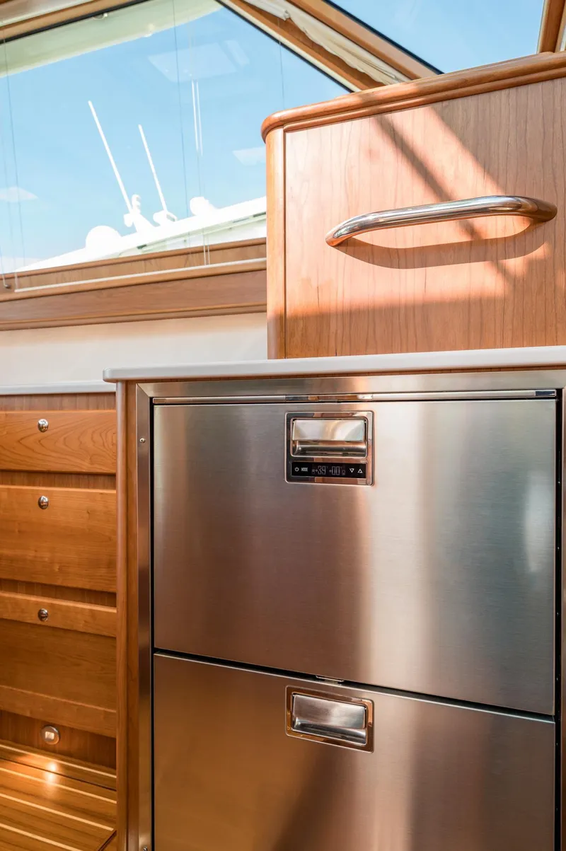 Slide: The Image of Modern kitchen interior of 2025 Sabre 43 Salon Express yacht, featuring stainless steel appliances and wood cabinetry. - 39