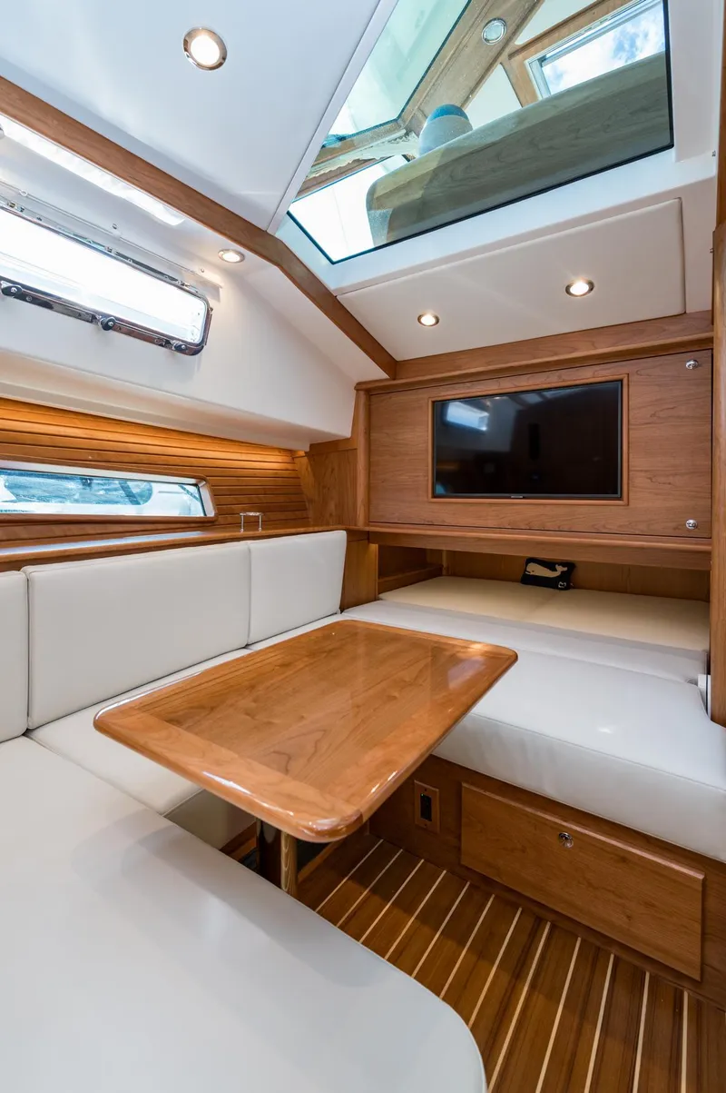 Slide: The Image of 2025 Sabre 43 Salon Express interior with wood finish, skylight, and seating area. - 44