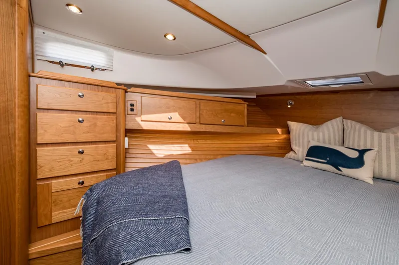 Slide: The Image of Luxurious 2025 Sabre 43 Salon Express cabin with wooden cabinetry and cozy bedding. - 49