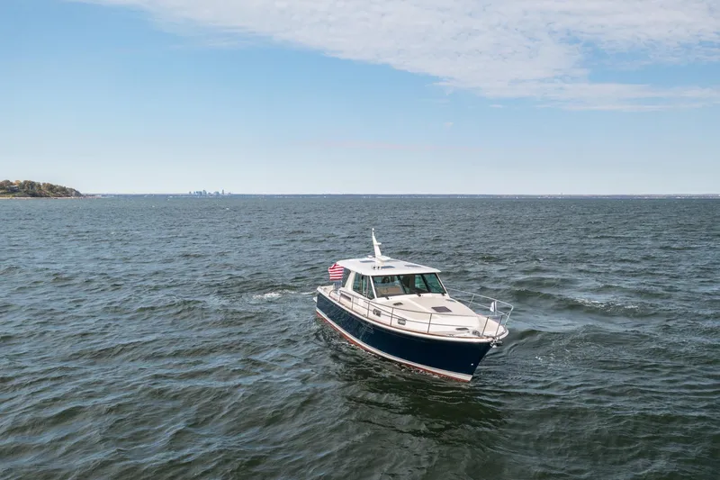 Slide: The Image of 2025 Sabre 43 Salon Express cruising on open water under a clear sky. - 5