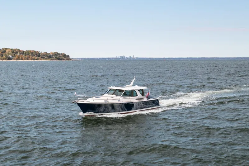 Slide: The Image of 2025 Sabre 43 Salon Express cruising on open water with distant shoreline. - 8