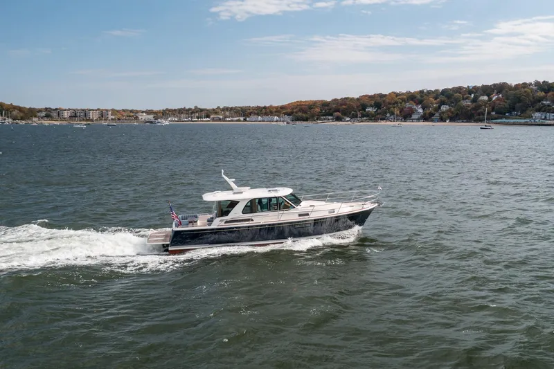 Slide: The Image of 2025 Sabre 43 Salon Express cruising on a scenic coastal waterway. - 9