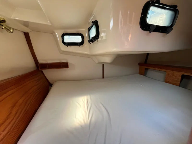 Slide: The Image of Cozy cabin interior of 1992 Hunter 30-2 sailboat with wooden accents and portholes. - 29