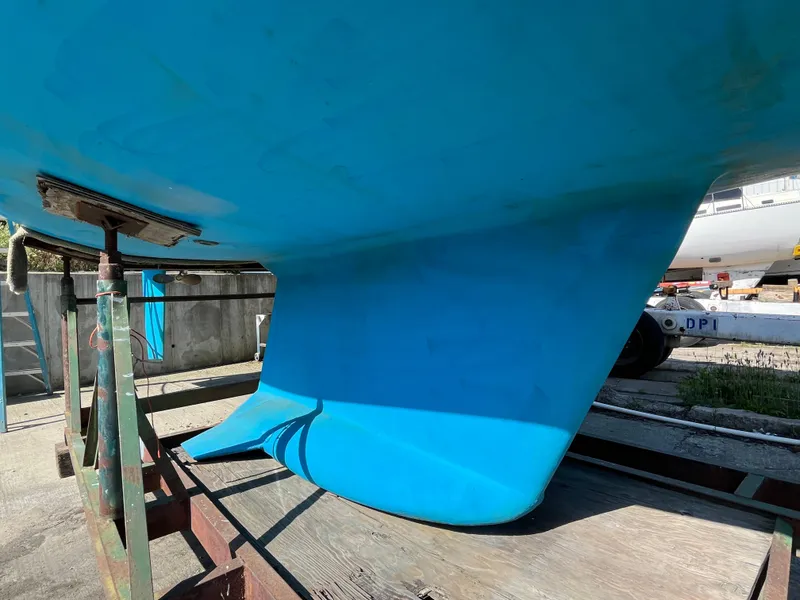 Slide: The Image of Blue hull of a 1992 Hunter 30-2 sailboat on a stand in a boatyard. - 37