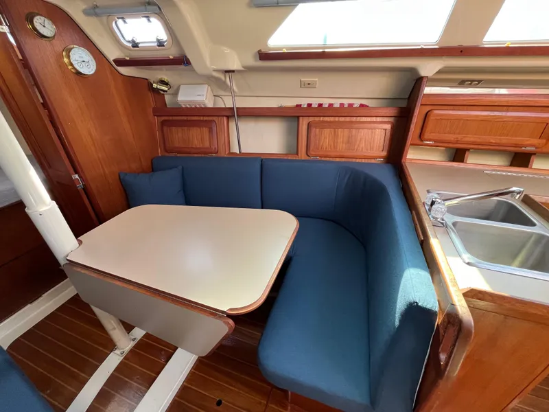 Slide: The Image of Interior of 1992 Hunter 30-2 sailboat with blue seating and wooden cabinetry. - 4