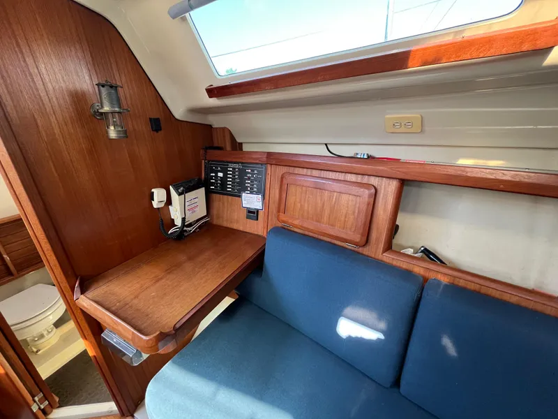 Slide: The Image of Interior of a 1992 Hunter 30-2 sailboat with wooden cabinetry and blue seating. - 6