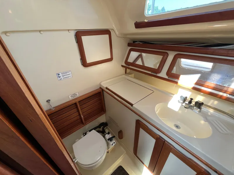 Slide: The Image of Interior of 1992 Hunter 30-2 sailboat bathroom with sink, toilet, and wooden accents. - 9