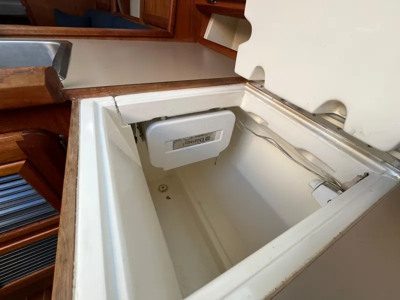 Slide: The Image of Open storage compartment in 1992 Hunter 30-2 sailboat interior, featuring wooden cabinetry. - 3
