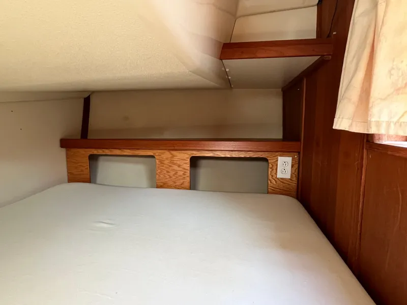 Slide: The Image of Interior cabin of 1992 Hunter 30-2 sailboat with wooden accents and bed. - 30