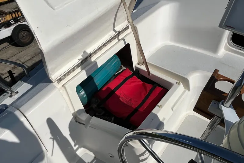 Slide: The Image of Open storage compartment on 1992 Hunter 30-2 sailboat, revealing red and teal items inside. - 32
