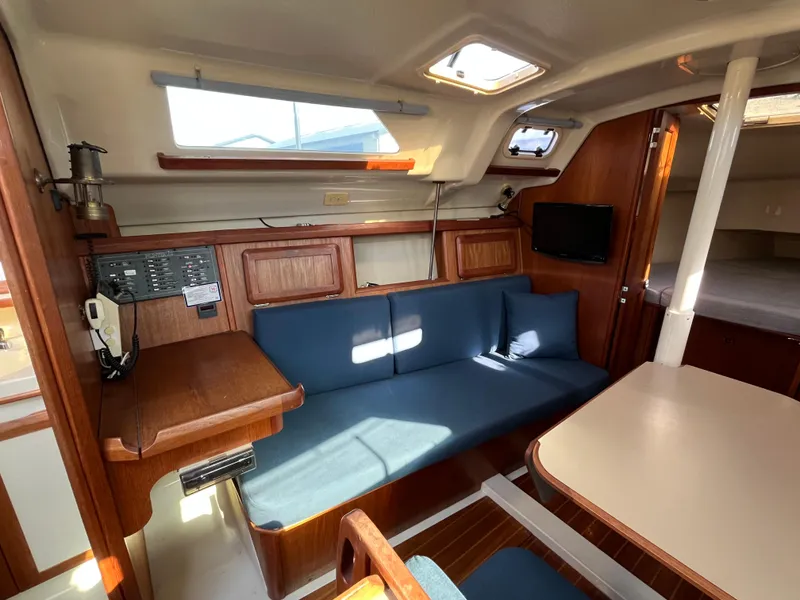 Slide: The Image of Interior of 1992 Hunter 30-2 sailboat with blue seating and wooden accents. - 5