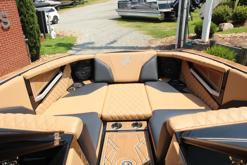 Slide: The Image of 2024 Tigé 24RZX boat interior with tan and black seating, cup holders, and speakers. - 12
