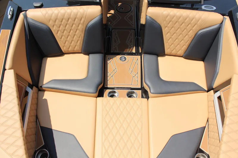 Slide: The Image of 2024 Tigé 24RZX boat interior with tan and gray diamond-stitched seating and cup holders. - 13
