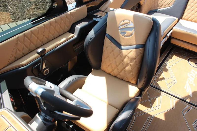 Slide: The Image of 2024 Tigé 24RZX boat interior with luxurious tan and black seating, stylish steering wheel. - 8