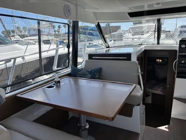 Slide: The Image of Interior of 2020 Jeanneau NC 1095 Fly yacht with dining area and marina view. - 12