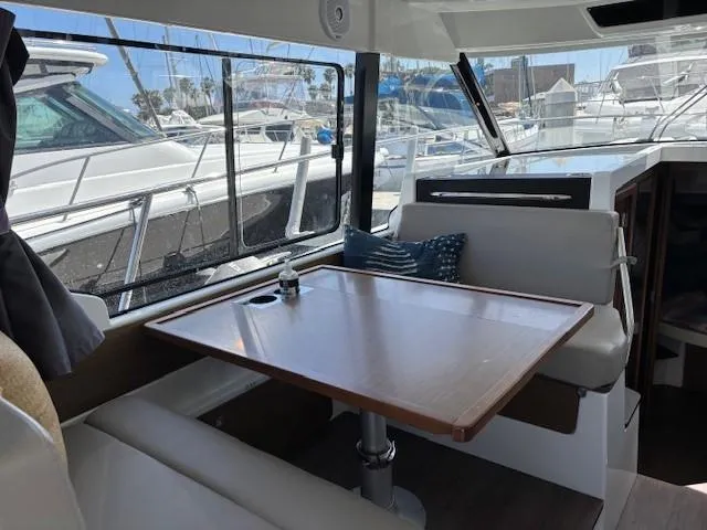 Slide: The Image of Interior of 2020 Jeanneau NC 1095 Fly with dining area and marina view. - 13