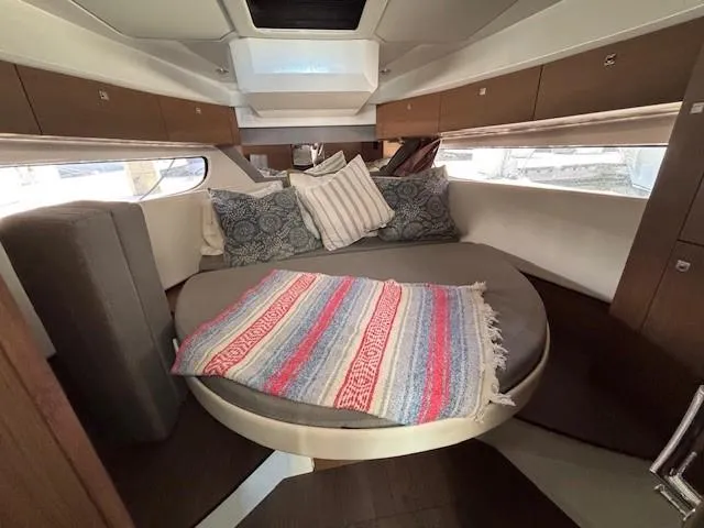 Slide: The Image of Cozy cabin interior of 2020 Jeanneau NC 1095 Fly with round bed and colorful blanket. - 19