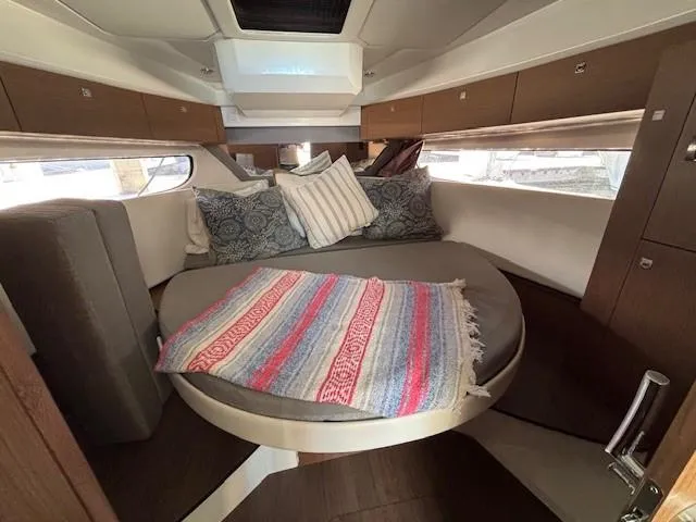 Slide: The Image of Cozy cabin interior of 2020 Jeanneau NC 1095 Fly with round bed and colorful blanket. - 20