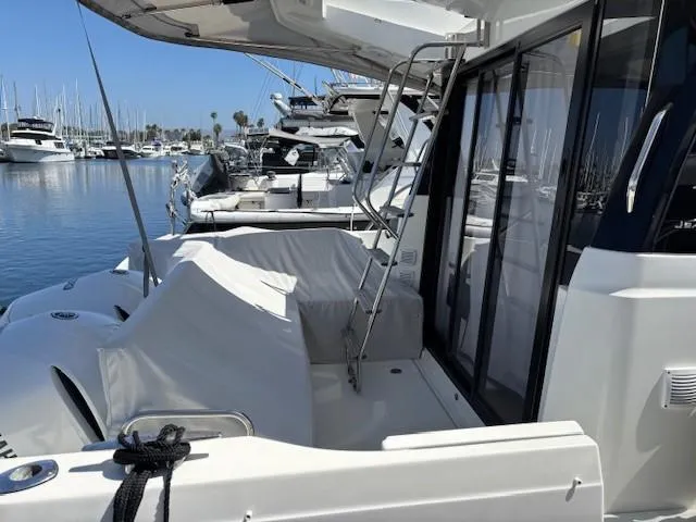 Slide: The Image of 2020 Jeanneau NC 1095 Fly yacht docked in a marina, showcasing sleek design and spacious deck. - 26